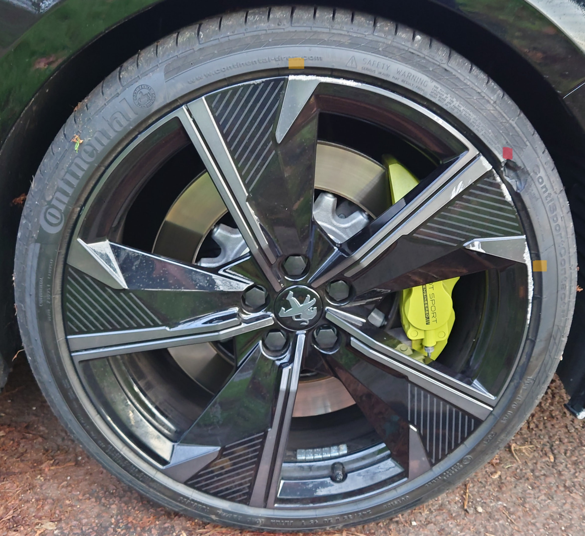 Close-up of an alloy wheel with curb rash and tyre sidewall damage, highlighted by TYREMOTION.